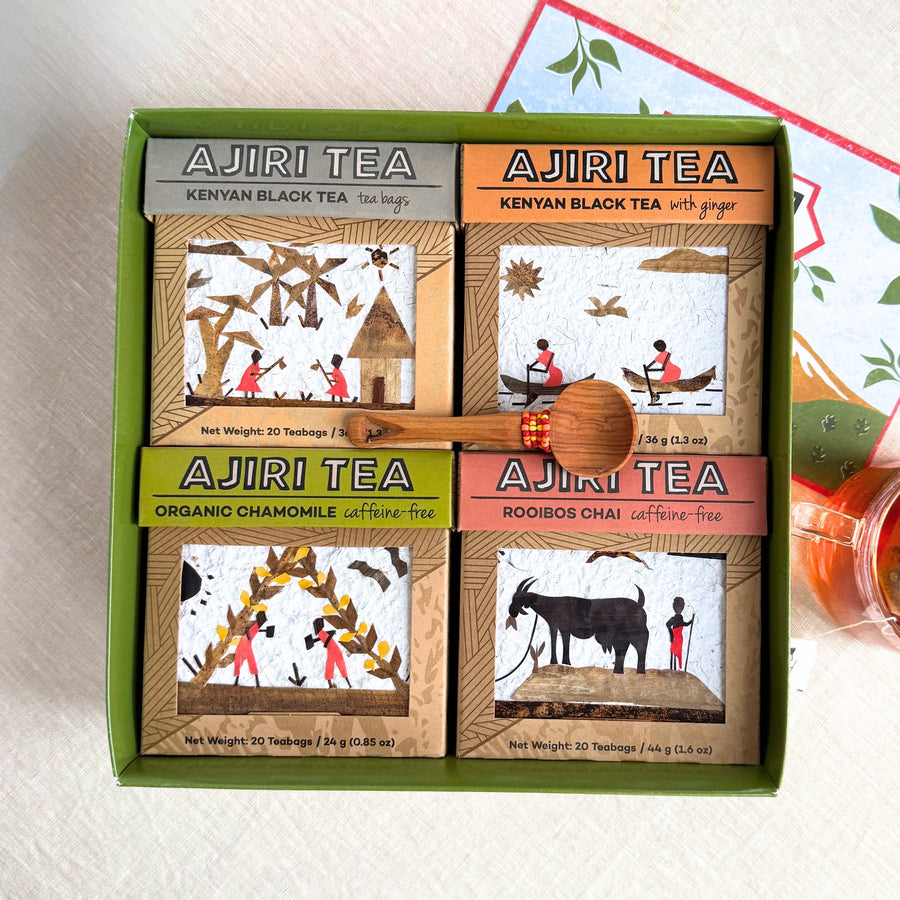 Open Ajiri Tea gift box with four handcrafted tea boxes: Kenyan Black Tea, Kenyan Black Tea with Ginger, Organic Chamomile and Rooibos Chai, with a wooden scoop