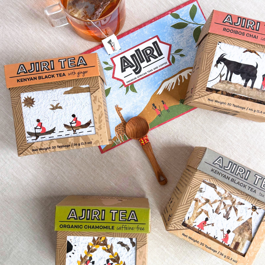 Ajiri teas with handmade art labels arranged around the Ajiri gift card, a cup of tea and a beaded wooden scoop