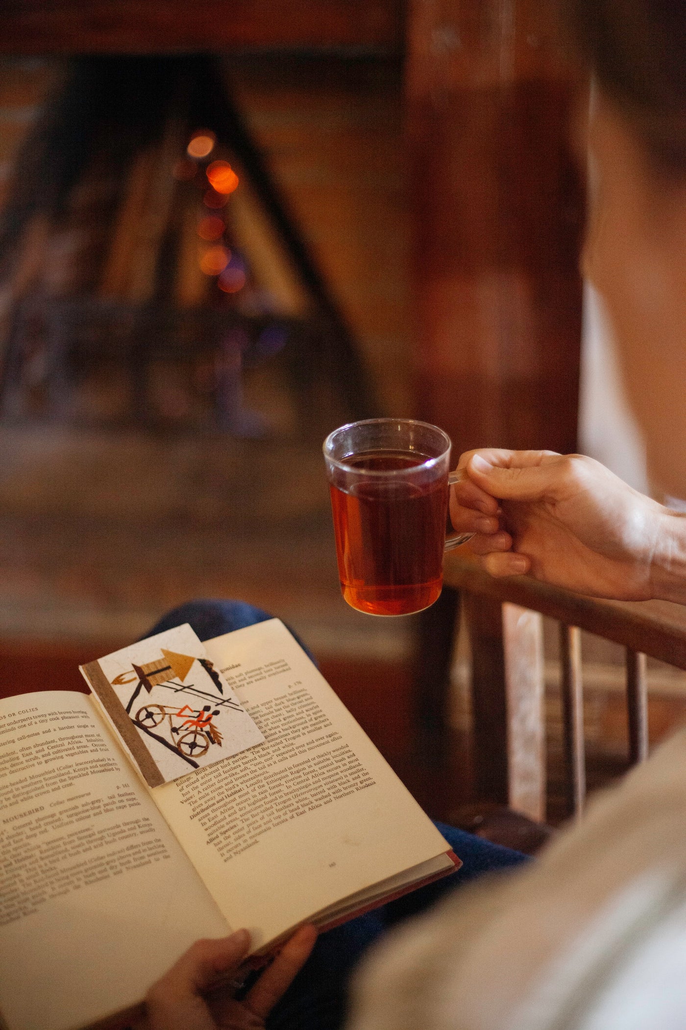 A glass of Ajiri tea beside an open book and a handmade Ajiri card